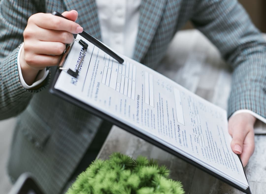 An insurance agent reviewing a surety bond policy document with a client, similar to arranging a continuous customs bond