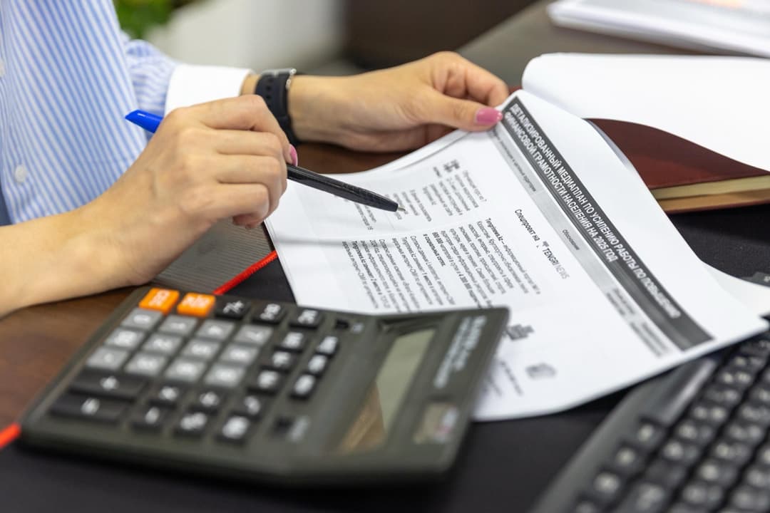 Calculator and customs paperwork on a desk, used to work through an import duty calculation