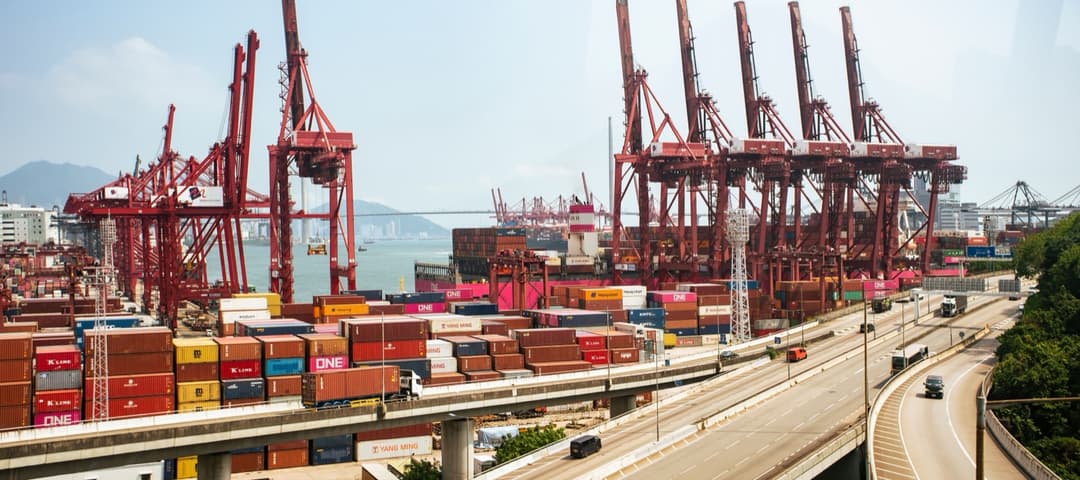 Cranes and stacked cargo containers at a port on a China-to-USA shipping lane, illustrating the china tariff duty stack